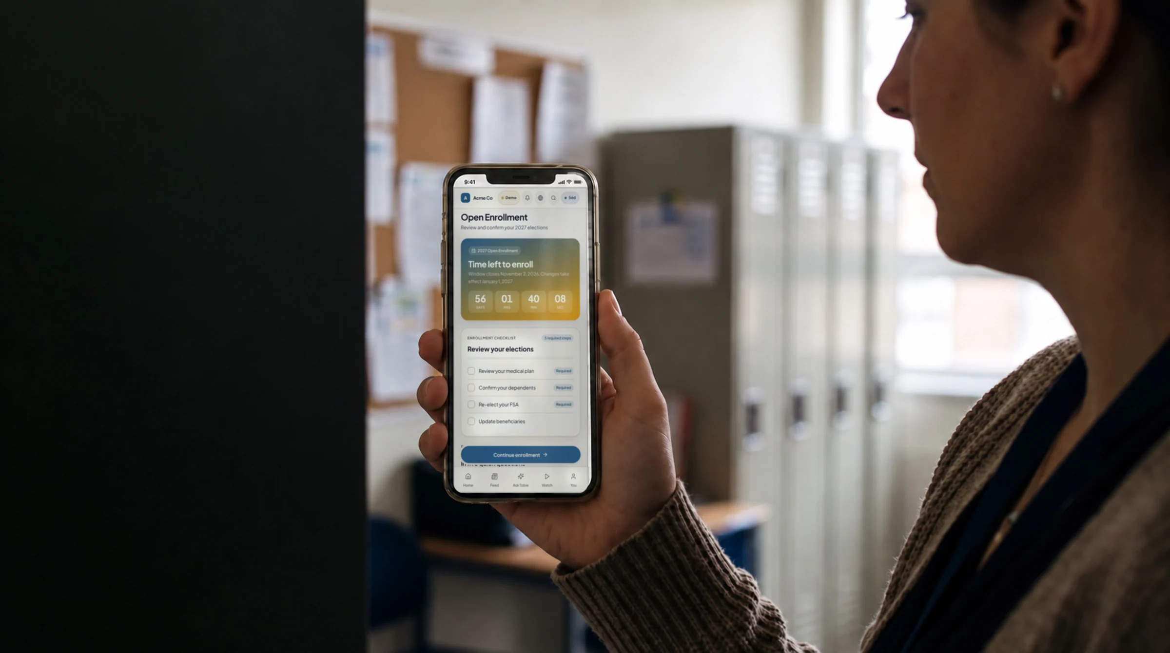 A teacher in a school staff room, reviewing her open enrollment checklist on her phone
